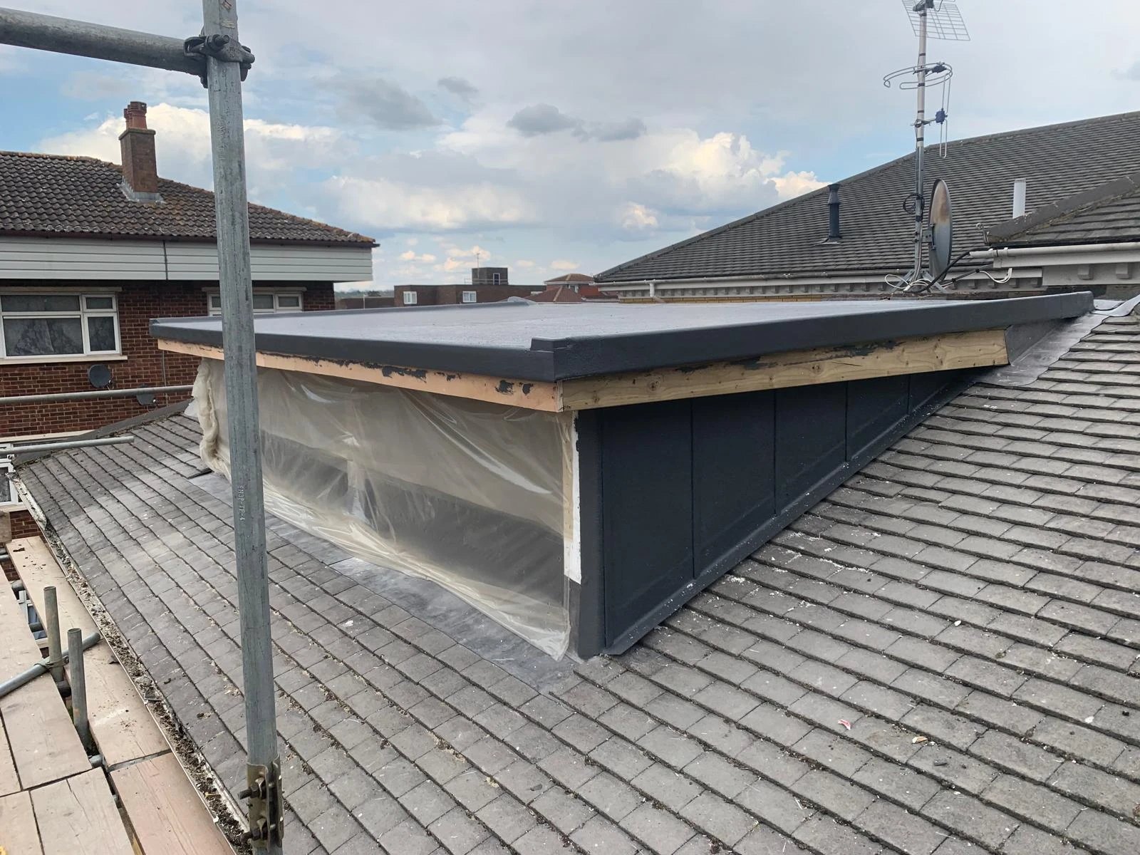Flat roofed rear dormer with clad cheeks on a tiled roof, before the windows went in