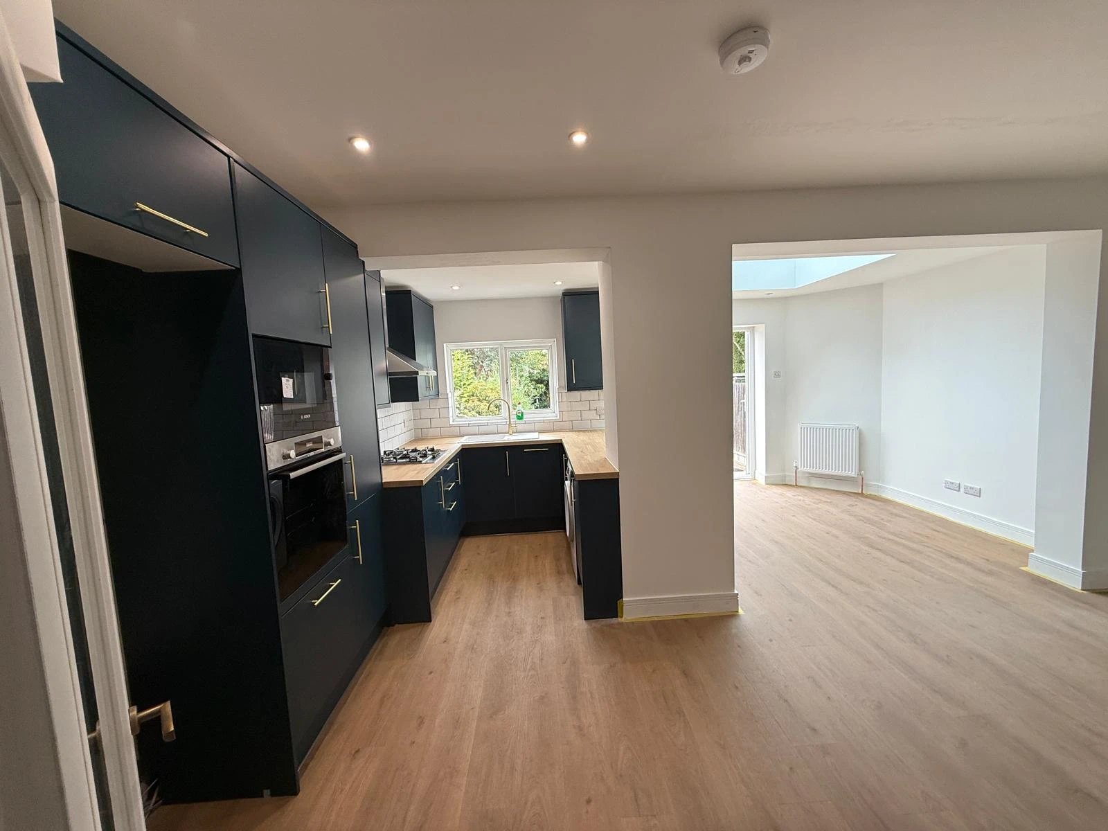 Navy kitchen with oak worktops opening into a bright rear extension