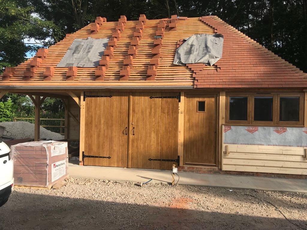 Oak framed garage with clay tiles going on the roof
