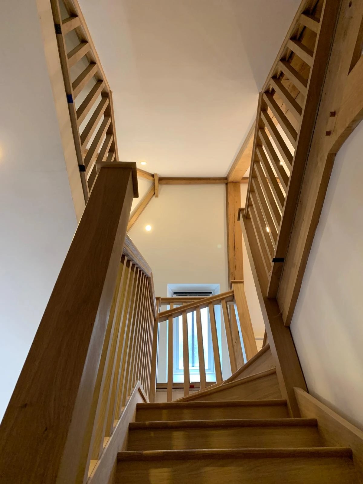 Oak staircase and galleried landing seen from below