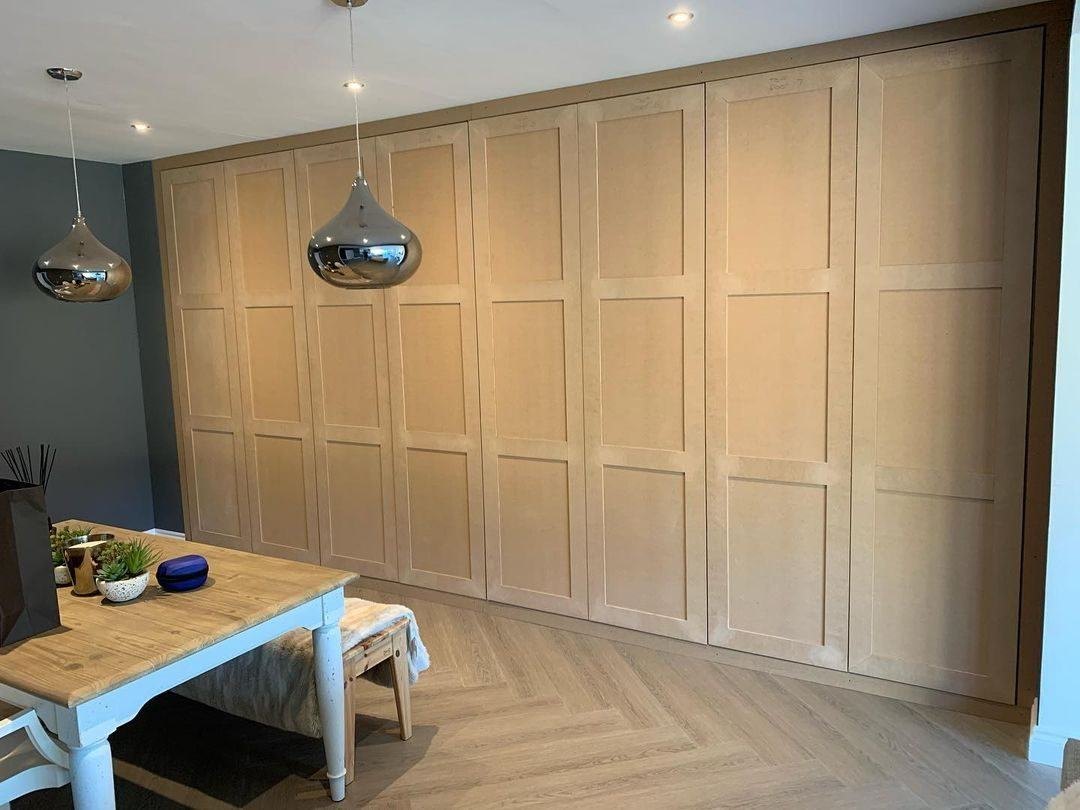 The same panelled wardrobe wall built and primed, before painting