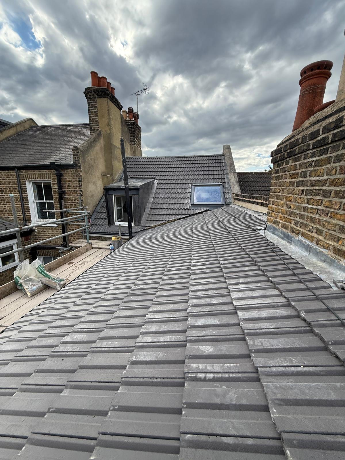 Terraced house roof retiled with a rooflight and dormer behind